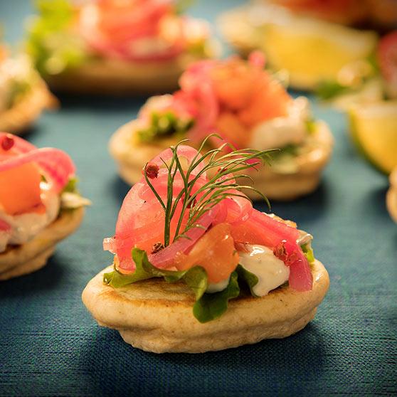 Mini Breakfast Blinis with Smoked Salmon, seasonal baby leaves, crème fraiche with horseradish & dill with red onion pickle